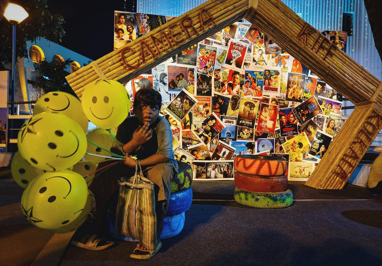 Vibrant street scene in Kolkata featuring a balloon vendor with striking artwork backdrop.